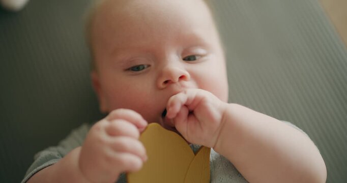 Close-up Baby Chewing Teether with Hands in Mouth