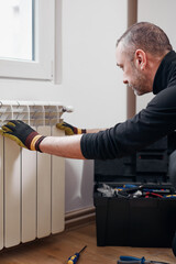 Central heating mechanic and handyman fixing home radiator, gas crisis and seasonal issues.