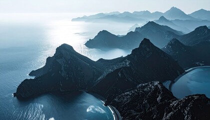 Misty mountain ranges meet tranquil sea
