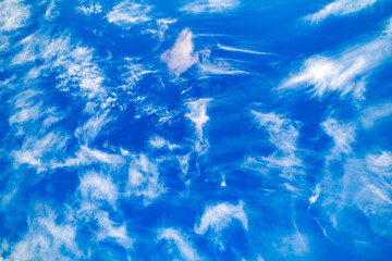 feathery sparse clouds in blue sky