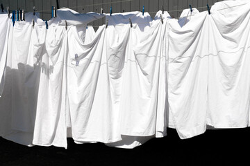 freshly laundered linen and white sheets dried on clotheslines