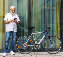 Bicycle, phone and thinking with business senior man outdoor in city for communication or commute. Building, directions on mobile app and serious mature employee with green transportation for cycling.
