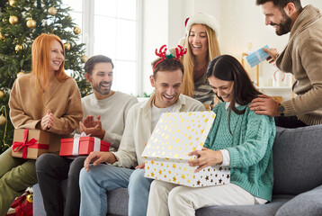 Happy New Year fun, Merry Christmas celebration friend party opening gift presents celebrating New year eve together, excited people having fun enjoying celebration together at home near festive tree