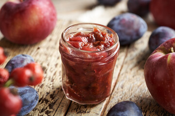Homemade chutney in glass jars - relish made with plums, apples, onions and spices