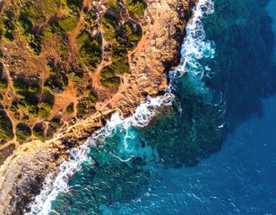 High-angle view of coastal cliffs meeting turquoise ocean waves