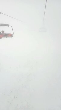 Chairlift ride in heavy fog at Kola&scaron;in 1600 ski resort. Concepts of seasonal leisure, active holidays, winter tourism in Montenegro, cinematic mountain landscapes, cold season adventure travel