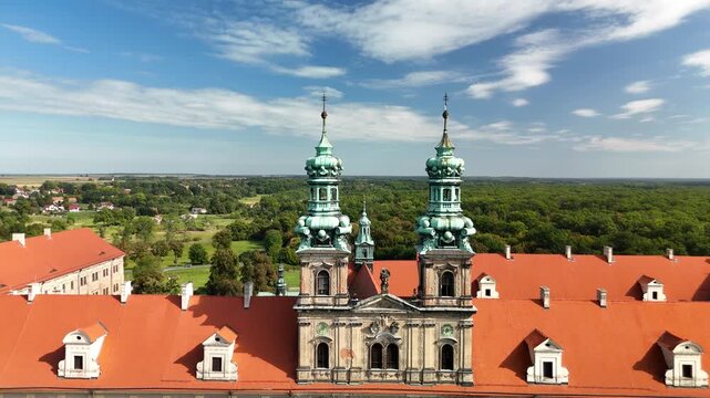 Aerial drone view of Cistercian Abbey in Lubiąż, Lower Silesia, Poland, surrounded by lush green forests, river, and scenic countryside landscape, historic monastery and cultural heritage site