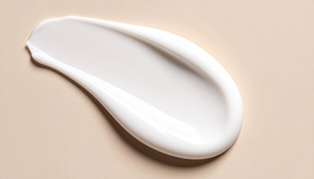 Smooth, creamy white lotion smear on a light beige background
