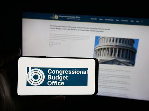 Stuttgart, Germany - 09-26-2025: Person holding smartphone with logo of US agency Congressional Budget Office (CBO) on screen in front of website. Focus on phone display.