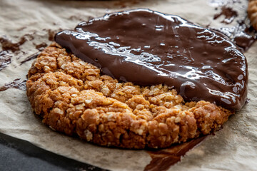Close-up of chocolate-coated oat biscuits stacked together, styled as a sweet treat or dessert snack background.