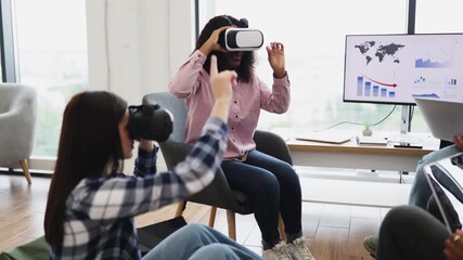 Women interacting with virtual reality technology wearing VR glasses in office setting. Exploring immersive digital experience, modern technology engaging workplace activities. - Powered by Adobe