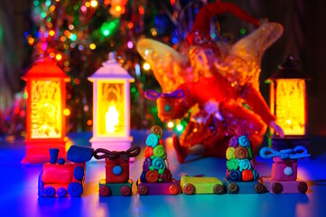 A toy train made of plasticine, a fairy with a gift and glowing lanterns. Fabulous scenery.