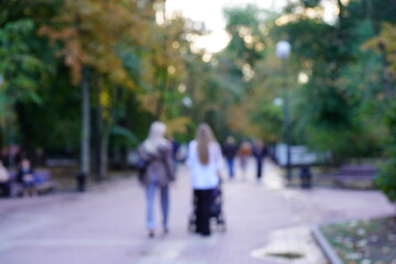 Blurred background. People are walking along a city street.