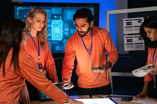 Tech professionals analyzing digital prototypes and sharing ideas during a meeting. Diverse colleagues brainstorming ideas, startup project, collaborate on product development, innovation and strategy