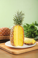 Fresh Golden Pineapple Cut in Half Showing Sweet Yellow Flesh on Wooden Board