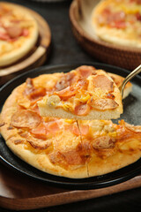 Delicious bacon and ham pizza with melted cheese on cast iron pan - homemade baking
