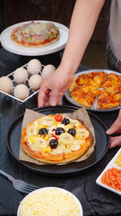 Homemade Pizza Making with Fresh Toppings and Ingredients in Kitchen