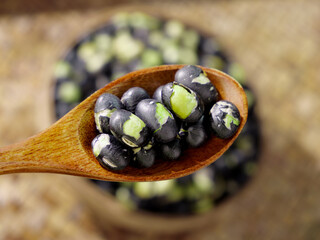 Fried Salted Black Beans on Wooden Spoon - Traditional Asian Legume Snack Food