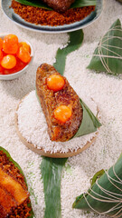 Handmade Glutinous Rice Dumplings with Salted Egg Yolk and Pork Filling on Bamboo Leaves