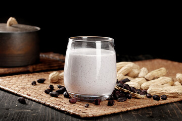 Creamy Peanut Smoothie with Raw Peanuts and Coffee Beans on Rustic Wooden Background