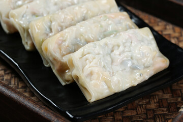 Handmade Vegetarian Spring Rolls with Fresh Vegetable Filling on Black Serving Plate