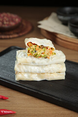 Handmade Fresh Vegetarian Spring Rolls with Vegetable Filling on Slate Serving Board