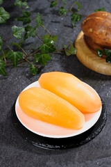 Fresh Yellow Papaya Slices on Plate with Herbs and Wooden Bowl Natural Food Styling
