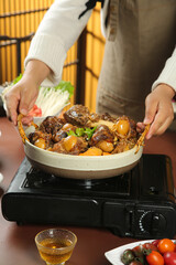 Hot Lamb Stew with Bones in Ceramic Pot - Traditional Cooking on Portable Burner