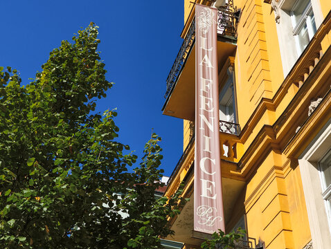 Prague, czech republic - september 7, 2025: la fenice hotel sign hanging on yellow building in prague