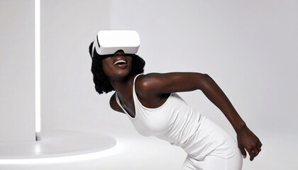 A joyful young woman with dark skin in a white outfit laughs while leaning back and experiencing a virtual world through a VR headset in a futuristic white studio.