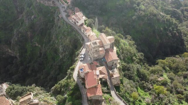 Aerial drone footage of Savoca in Sicily, the historic village famous for The Godfather, showing dramatic clouds, peaceful streets, traditional architecture, and surrounding nature.
