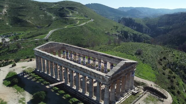 Stunning 4K footage of the Doric Temple of Segesta in Sicily, capturing the ancient Greek architecture surrounded by rolling hills, Mediterranean scenery, and bright summer sunlight in the Parco Arche