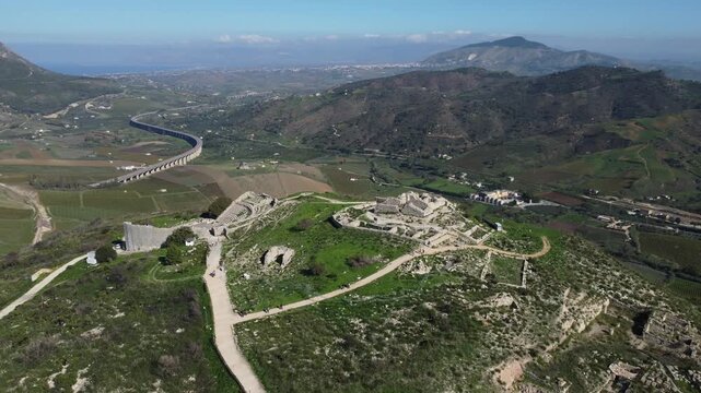 Beautiful 4K footage of Teatro di Segesta in Sicily, showcasing the ancient Greek theatre surrounded by rolling hills, Mediterranean landscapes, and clear summer skies in the Parco Archeologico di Seg
