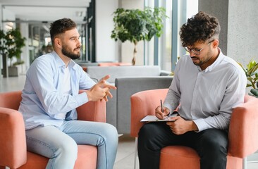 Psychologist taking notes while listening to patient talking about problems