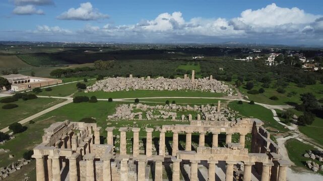 Cinematic 4K footage of Tempio di Hera E at Selinunte Archaeological Park, Sicily, showcasing the grandeur of ancient Greek architecture surrounded by Mediterranean landscapes and clear summer skies.