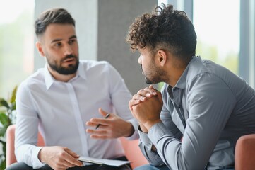 Psychologist supporting upset arab man during therapy session