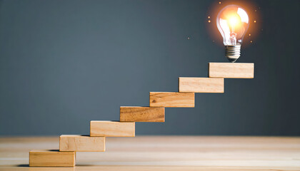 Wooden blocks forming stairs leading to a glowing light bulb symbolizing innovation, creativity, and progress.