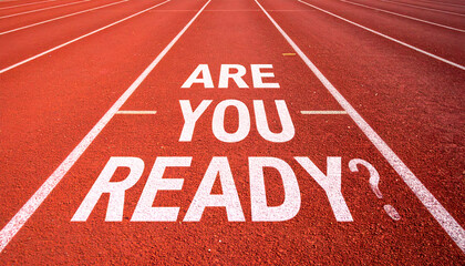 Motivational message "ARE YOU READY?" painted on running track symbolizing preparation and challenge.