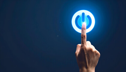 Hand pressing blue power button on dark background symbolizing start, activation, or innovation.