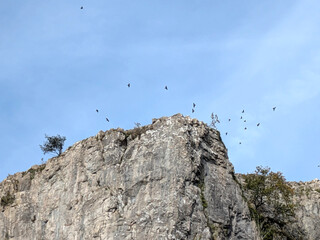 Tall cliff face jagged rocks and stone gorge mountins with clear sky in the UK landscape