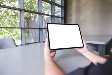 Mockup image of a woman holding digital tablet with blank white desktop screen