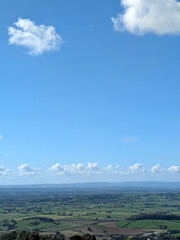 Beautiful British coutryside hills and landscape with green fields and woodland with a blue sky