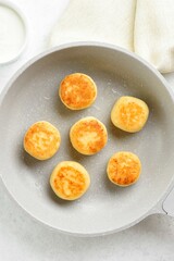 Cottage cheese pancakes (syrniki or curd fritters) in skillet