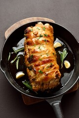 Roasted pork loin with rosemary and garlic in cast iron skillet