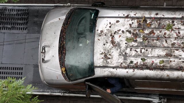 An old, inoperable, abandoned vehicle is being towed away by a tow truck