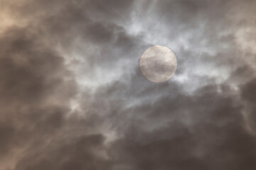 dramatic view on sun behind rain clouds
