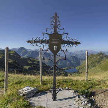 Forged memorial cross for Josef B&ouml;ck, master shepherd of the rear Seealpe, behind it mountain panorama from the Zeigersattel to the Seealpsee, on the left the H&ouml;fats 2259m, in the centre of the picture the Allg&auml;u main ridge with Trettachspitze 2595m, M&auml;delegabel 2645m, Bockkarkopf 2609m and Hochfrottspitze 2649m, Allg&auml;u Alps, Allg&auml;u, Bavaria, Germany