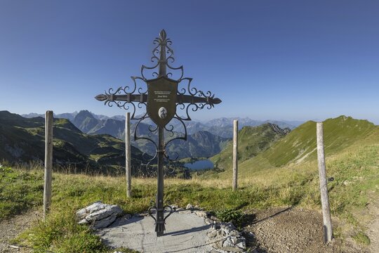 Forged memorial cross for Josef B&ouml;ck, master shepherd of the rear Seealpe, behind it mountain panorama from the Zeigersattel to the Seealpsee, on the left the H&ouml;fats 2259m, in the centre of the picture the Allg&auml;u main ridge with Trettachspitze 2595m, M&auml;delegabel 2645m, Bockkarkopf 2609m and Hochfrottspitze 2649m, Allg&auml;u Alps, Allg&auml;u, Bavaria, Germany