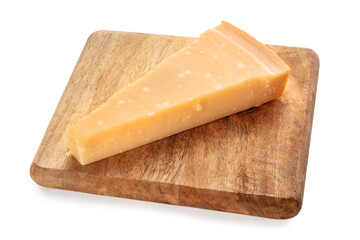 Parmesan cheese wedge on a wooden cutting board, isolated on a white background