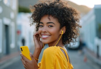 an african woman smiling and walking down the street, wearing yellow headphones around her neck